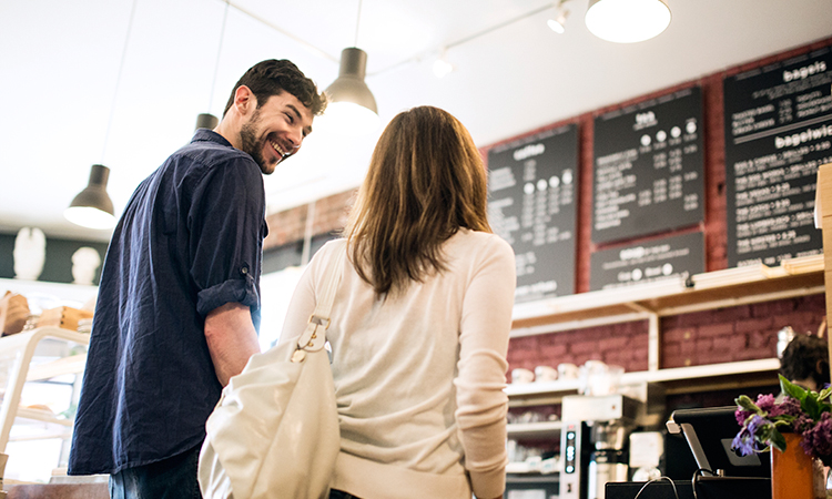 A couple standing in line at a coffee shop