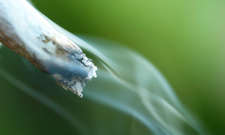 A lit cannabis joint emitting smoke