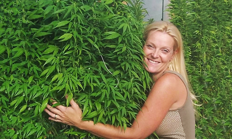 Toni Savage Fox, founder of 3D Cannabis Center, hugging cannabis plants
