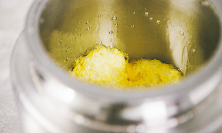 Cannabis extracts and spatula in a stainless steel container