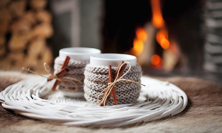 Tea cups on a table near a warm winter fire