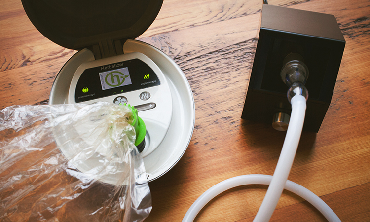 Two table-top cannabis vaporizers on a wooden table
